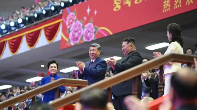 Xi, Kim, and their wives applauding at a banquet