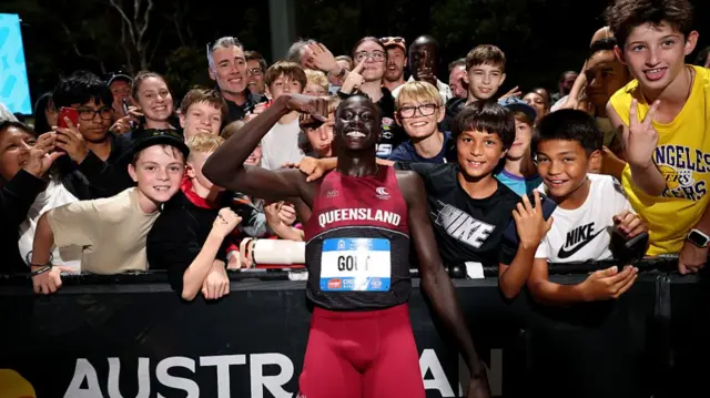 Gout Gout of Queensland poses with spectators after winning the Men's U20 100m Final during the 2025 Australian Open and Under 20 Athletics Championships at WA Athletics Stadium