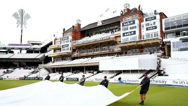 Ground staff remove the covers at the Oval