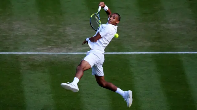 Felix Auger-Aliassime hits an overhead smash