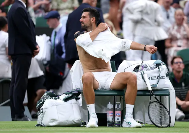Novak Djokovic of Serbia changes his shirt