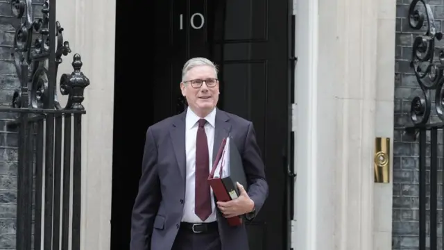 Keir Starmer steps out of 10 Downing Street holding two folders