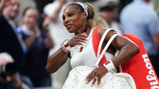 Serena Williams carries two bags containing tennis equipment