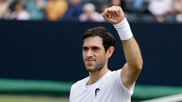 Nuno Borges, wearing a white t-shirt, raises a clenched left fist