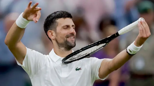 Novak Djokovic, holding his racquet in his left arm with the head tucked under his chin, plays it like a violin