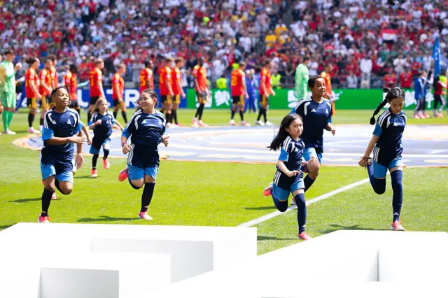 Kids run across the pitch