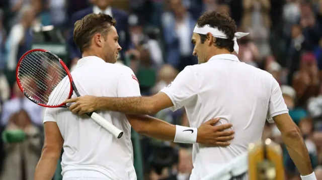 Marcus Willis and Roger Federer embrace at the net