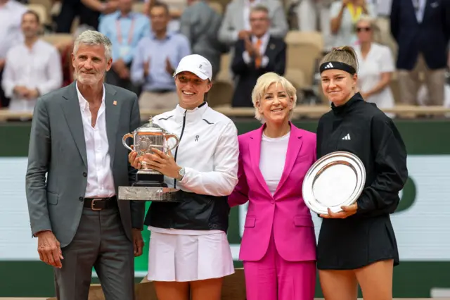 Iga Swiatek (second left) holding the French Open trophy with Karolina Muchova (right) holding the silver runners-up plate