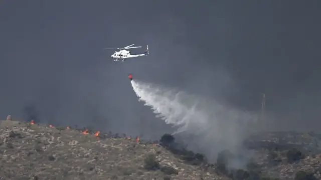 A picture taken on July 10, 2026 shows a water bombing helicopter on the site of a wildfire that killed 11 near Los Gallardos, in Almeria Province.