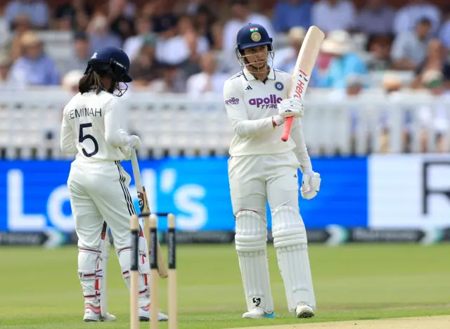 India's Smriti Mandhana acknowledges the crowd after reaching 50 runs during day one of the first Women's Rothesay Test at Lord's Cricket Ground, London