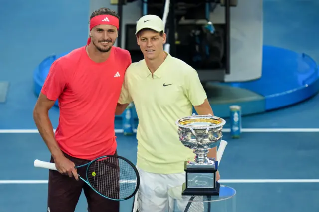 Alexander Zverev and Jannik Sinner pose with the Australian Open trophy in 2025