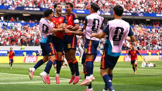 Spain players celebrate with Mikel Merino