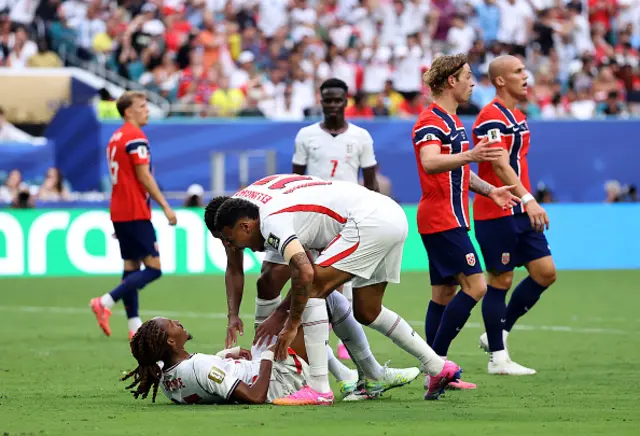 Djed Spence #25 of England is helped up by teammates