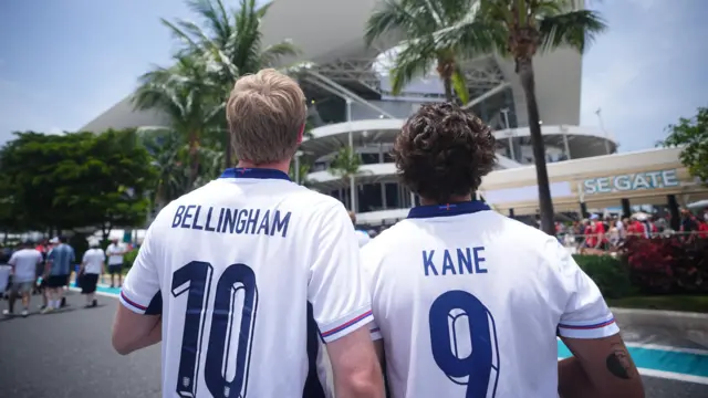 Fans with Bellingham and Kane shirts walk towards the stadium