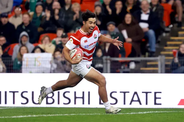 Japan's Main Taira reacts as he crosses the line to score a try