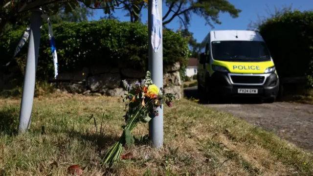 Flowers and a police vehicle outside the home of 78-year-old former government minister Ann Widdecombe.