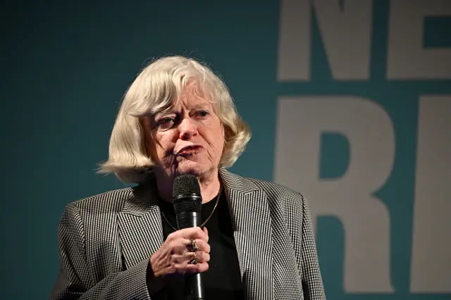 Ann Widdecombe wears a checked blazer and black top as she speaks into a microphone