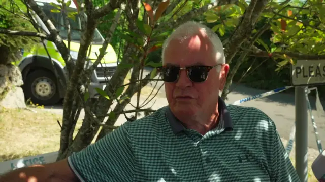 Peter Horrall sits under a tree near Widdecombe's home.
