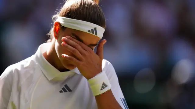 Karolina Muchova scratches her face