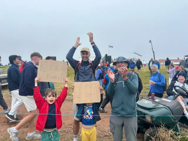 “No Rory, no party” chant these two youngsters as their hero walks past.