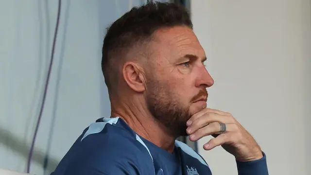 Brendon McCullum, facing to his left and looking straight ahead with his left hand on his chin and a look of resignation