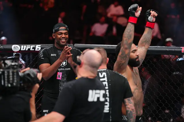 Jone Jones claps as Gable Steveson holds up his arms