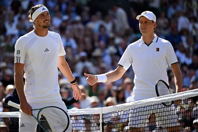 Alexander Zverev and Jannik Sinner stand together at the net