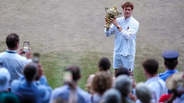 Jannik Sinner holds the Wimbledon trophy