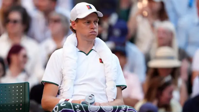 Jannik Sinner sits down on his chair