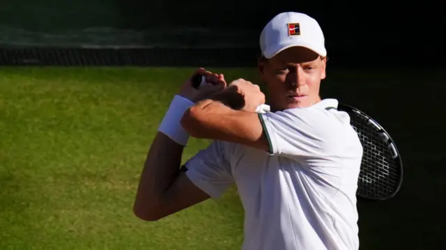 Jannik Sinner hits a backhand