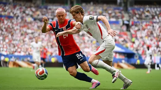 Anthony Gordon #18 of England runs with the ball under pressure from Julian Ryerson #26 of Norway during the FIFA World Cup 2026 Quarter Final match between Norway and England at Miami Stadium on July 11, 2026 in Miami Gardens, Florida