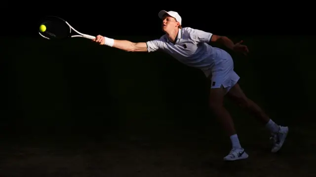 Jannik Sinner stretches for a forehand