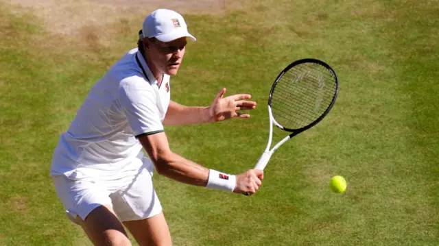 Jannik Sinner hits a backhand volley
