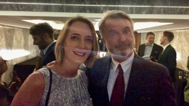 Lucy Hockings, with short brown hair, stood next to Sam Neill with several people behind them