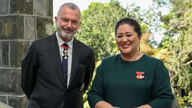 Sam Neill posing with Governor-General of New Zealand Dame Cindy Kiro after being knighted in 2022