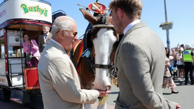 King Charles III, Lord of Mann, meets a member of staff during a visit to Douglas Promenade to celebrate 150 years of the Douglas Horse Tramway, on his trip to the Isle of Man.