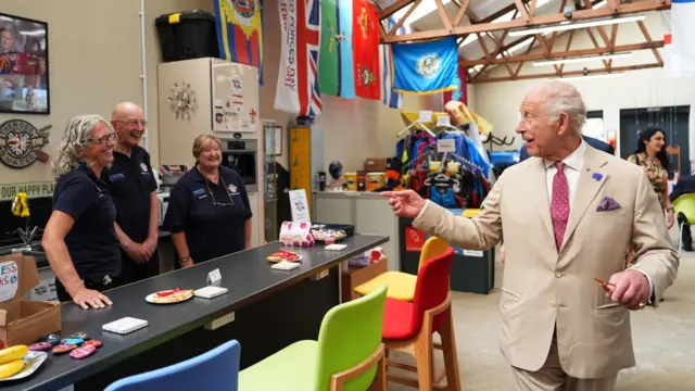 The King points to volunteers at a charity