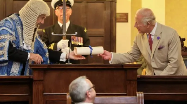 The president of Tynwald handing the King the scroll