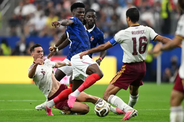 Thcouameni is tackled by two Spain players in midfield