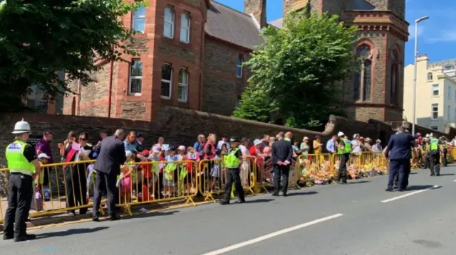 A large group of children behind a yellow barrier