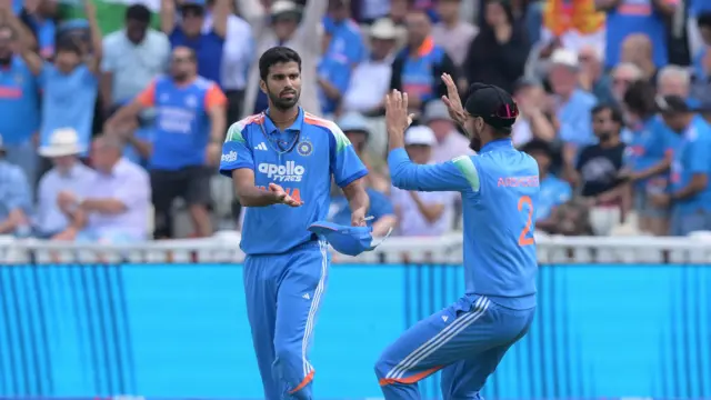 Washington Sundar (left) stretches his hands out for a high 10 with Arshdeep Sigh (right), with both players wearing all blue