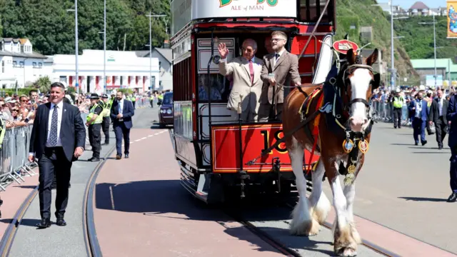 The King enjoys a ride on the horse tram