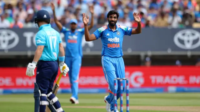 Jasprit Bumrah, wearing all blue, holds his hands up after nearly taking Ben Duckett's wicket, with Duckett, wearing dark blue trousers and bright blue top, facing him on the left