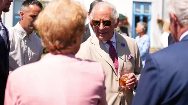 The King enjoys a drink at a garden party