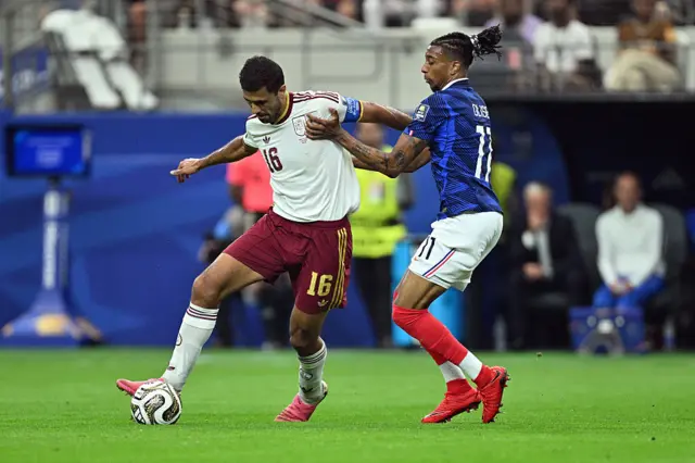 Rodri holds off Olise in midfield