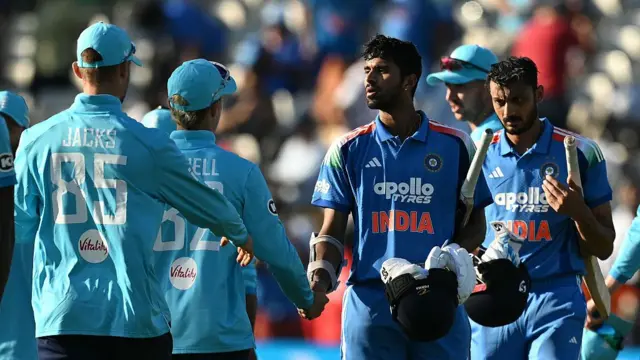 Axar Patel (right) and Washington Sundar (second right), wearing all blue with bats tucked under their arms, shake hands with Jacob Bethell and Will Jacks, wearing bright blue England kits