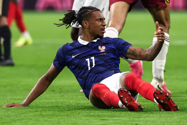 Olise waves at the referee after being fouled