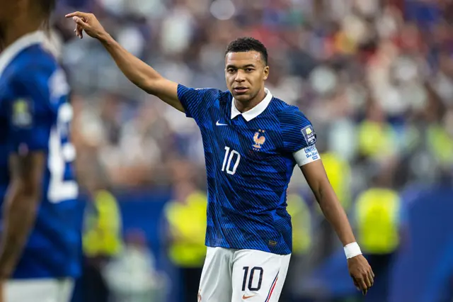 Mbappe waves his arm in a disgruntled manner