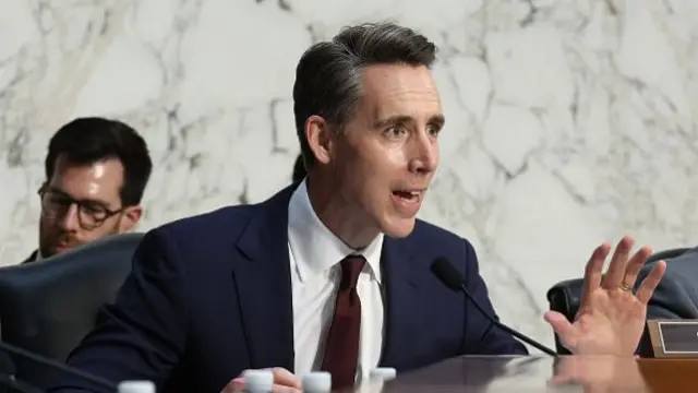 Josh Hawley wears a navy suit and burgundy tie
