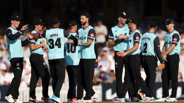 Jordan Clark (centre) is congratulated by Surrey team-mates for taking a T20 wicket